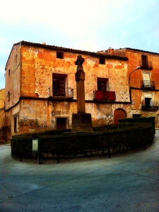 Plaza de los Mártires y Cruz de los Caídos por Dios y por España. Al fondo se pueden ver todavía los colores de FET de las JONS (Castelserás, Teruel).